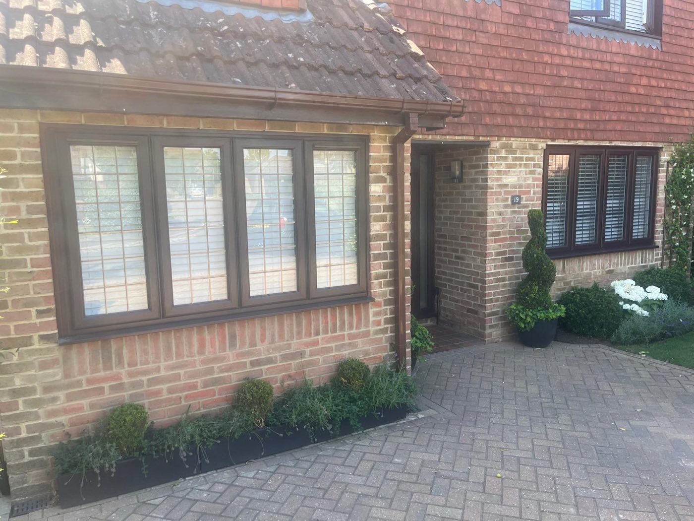 The converted garage exterior with new brickwork and a leaded window matching the existing house