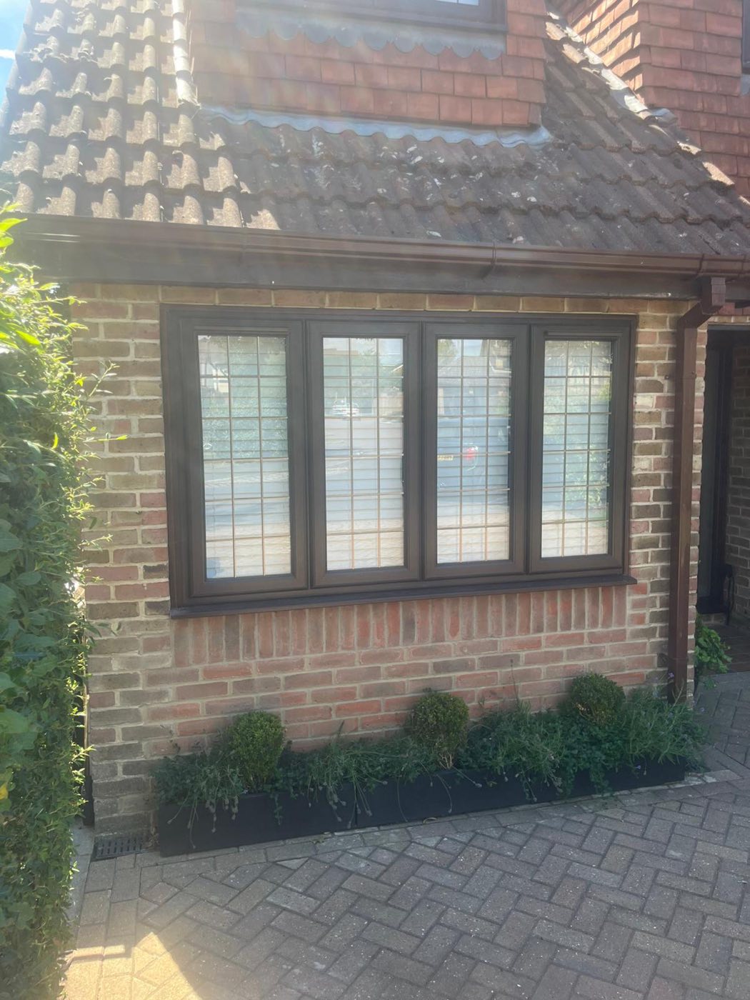 New four-pane leaded window set into brickwork where the garage door once was