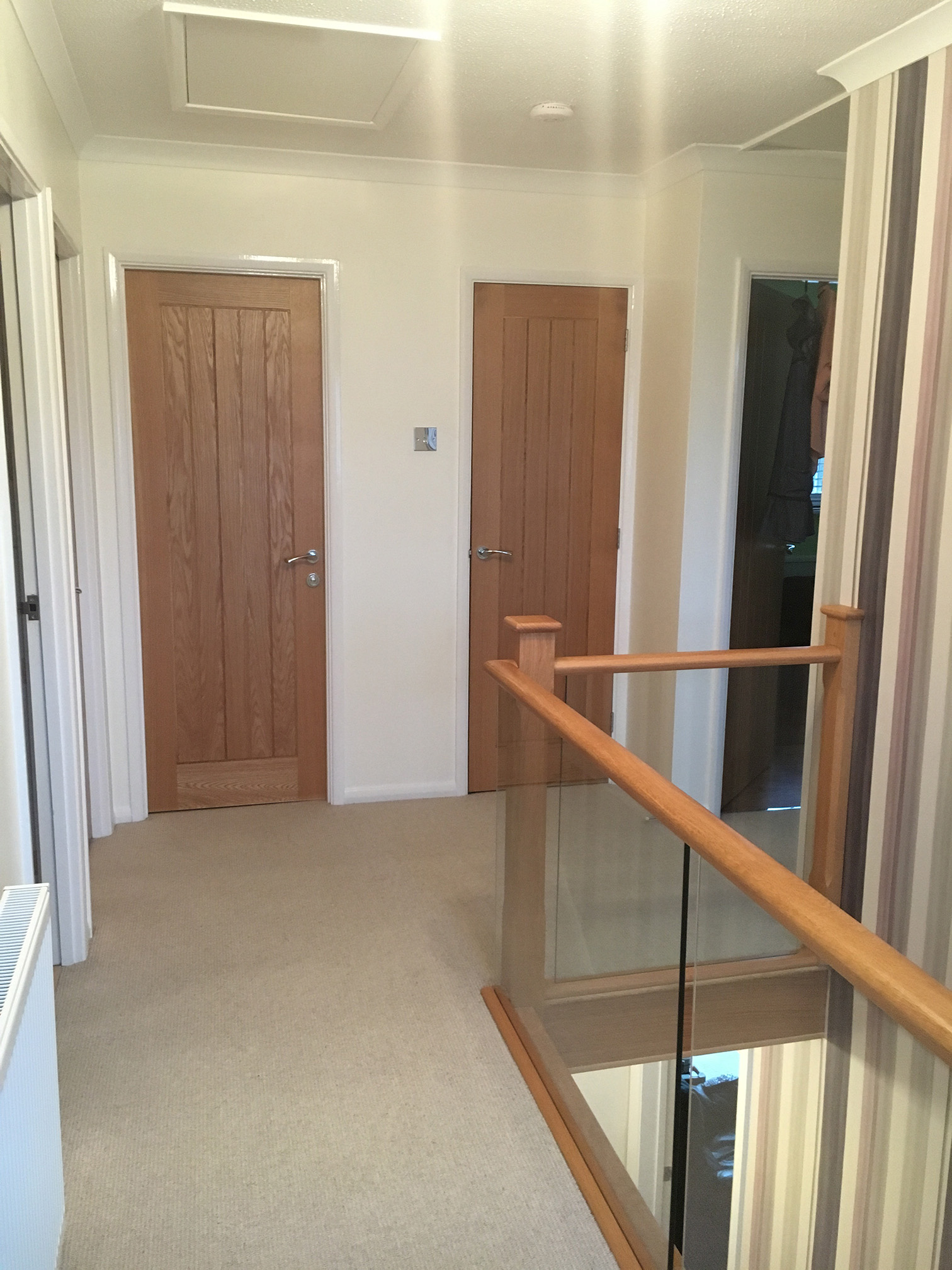Multiple oak doors fitted along landing